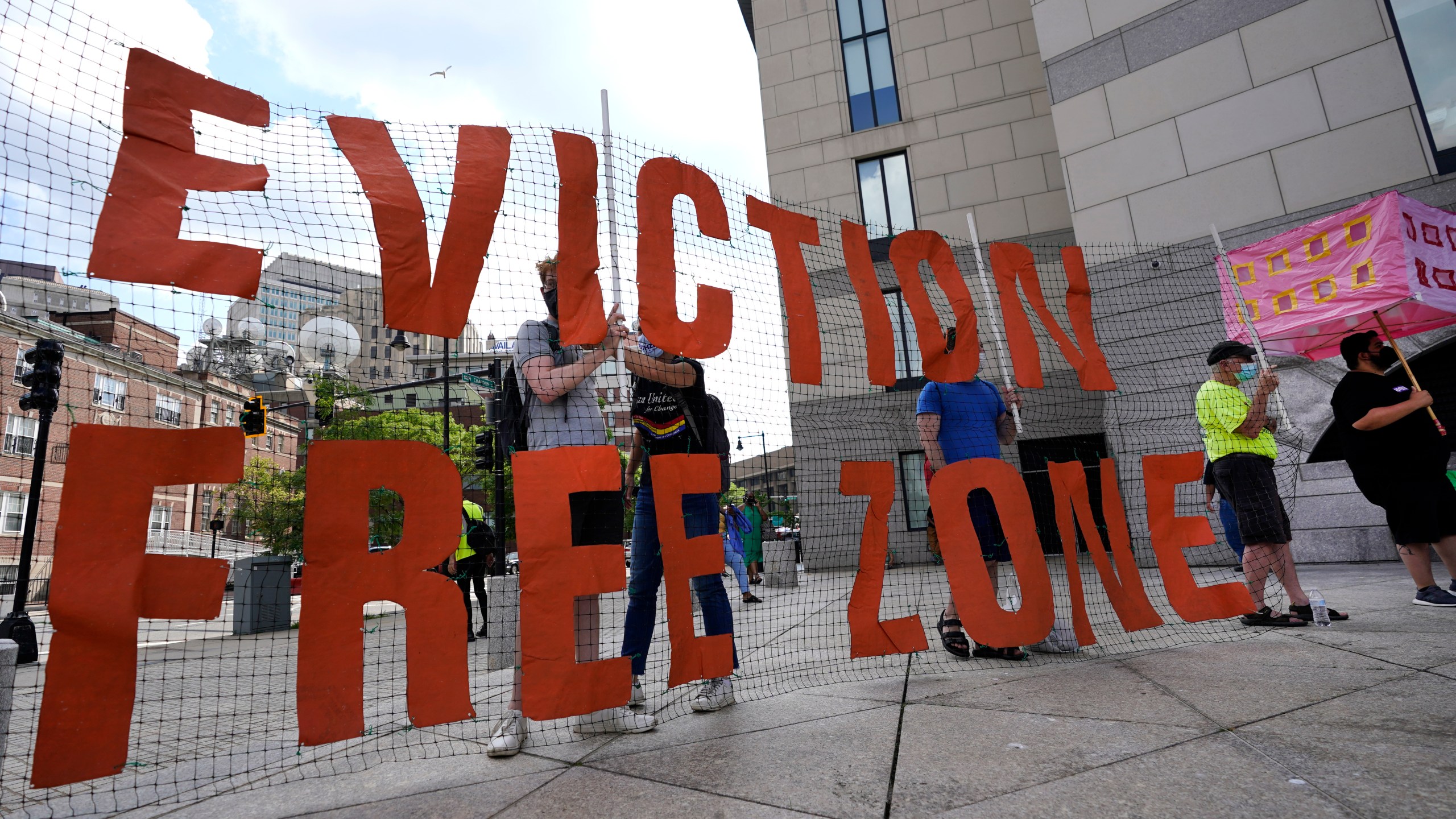 FILE - In this June 9, 2021, photo, people hold a sign during a rally in Boston protesting housing eviction. Housing advocates are raising the alarm about House Republicans' plan to dramatically cut the federal deficit to raise the debt ceiling, warning that struggling families could lose access to rental aid. (AP Photo/Elise Amendola, File)