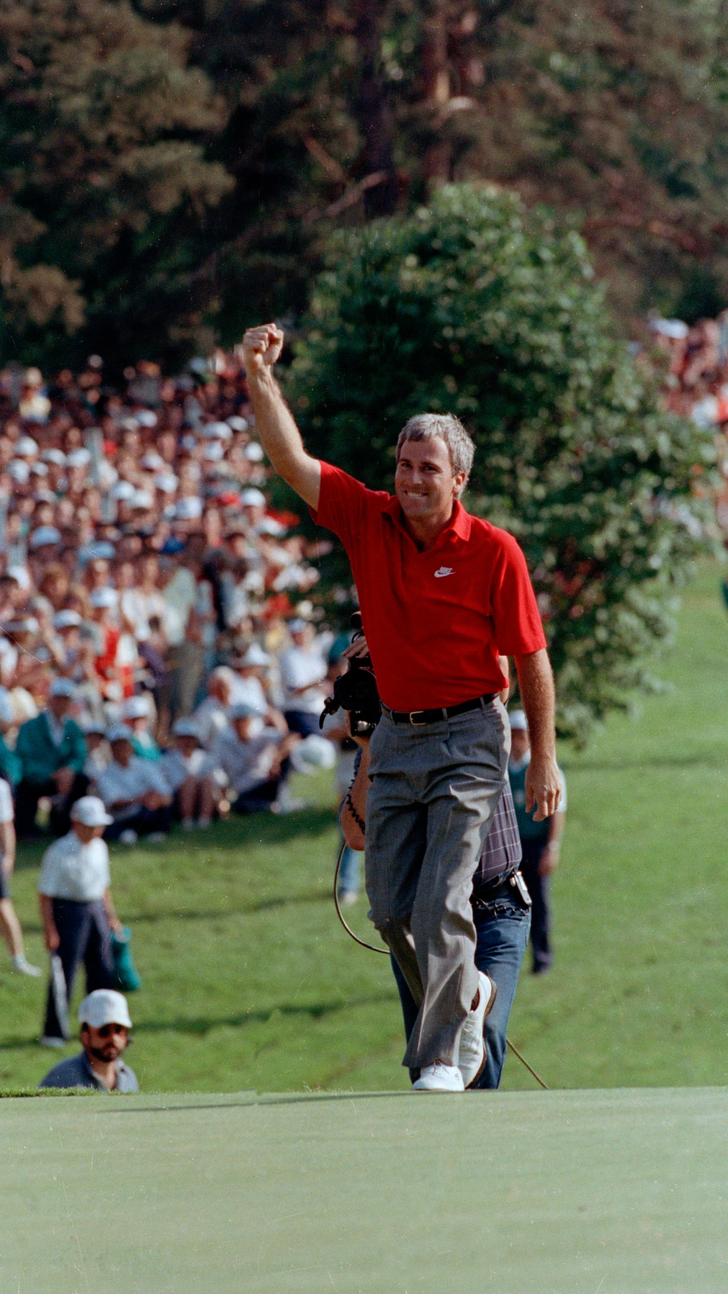 FILE- Curtis Strange reaches the 18th green waving to the crowd as he is about to win the U.S. Open for the second straight year, June 18, 1989, at the Oak Hill Country Club in Rochester, N.Y. Strange returns to Oak Hill for the PGA Championship on May 18-21 as part of the ESPN broadcast team. (AP Photo/Tom Kilips)