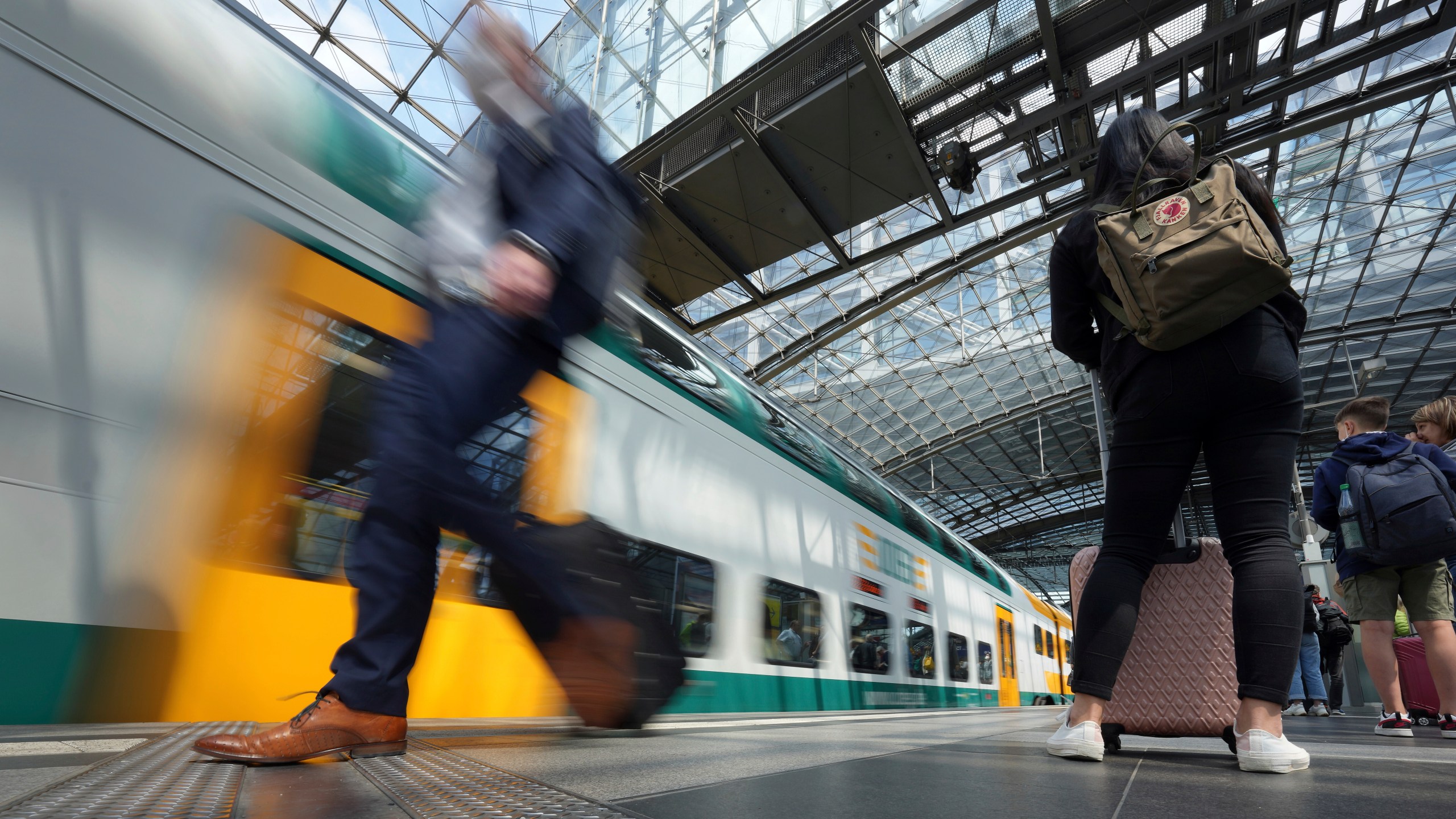 FILE - Travellers wait on a platform as a train arrives at the main train station in Berlin, Germany, Wednesday, June 1, 2022. A labor union representing more than 200,000 railway workers in Germany says it is cancelling plans for a two-day strike after employers met one of its key demands. (AP Photo/Michael Sohn, File)