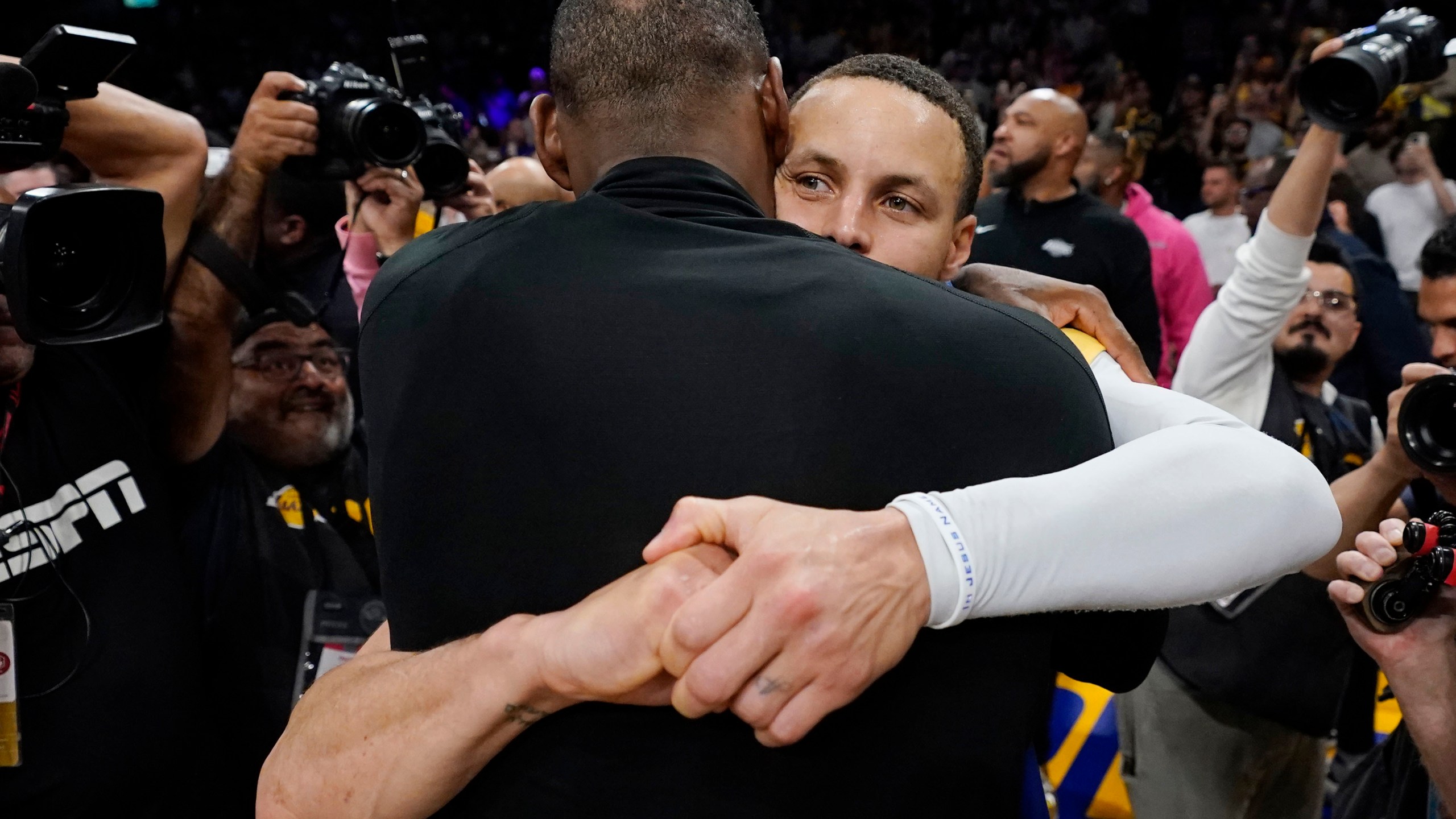 Los Angeles Lakers forward LeBron James, back to camera, hugs Golden State guard Stephen Curry after Game 6 of an NBA basketball Western Conference semifinal series Friday, May 12, 2023, in Los Angeles. Los Angeles won 122-101 to take the series and advance to the conference championship. (AP Photo/Ashley Landis)