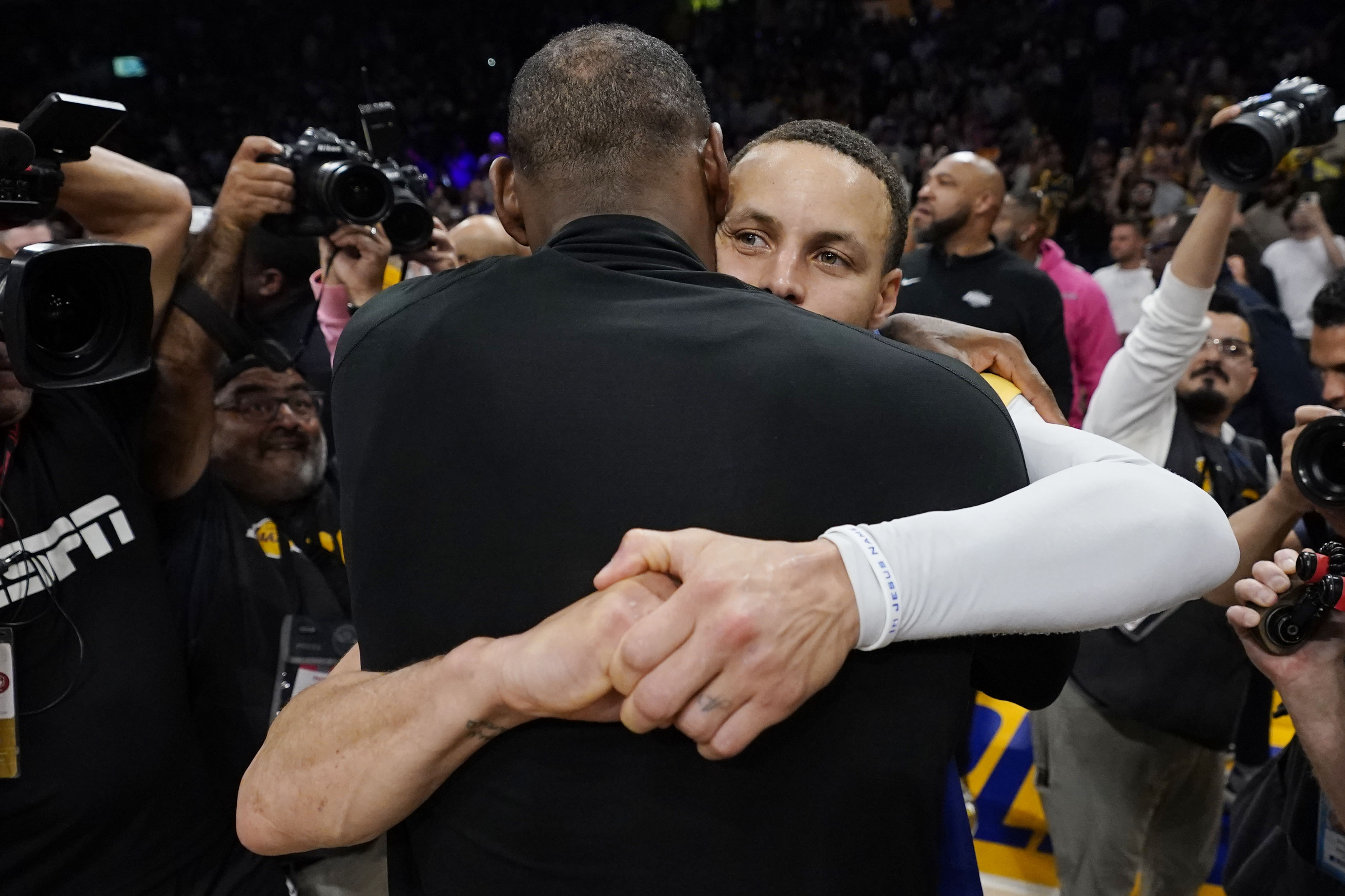 Los Angeles Lakers forward LeBron James, back to camera, hugs Golden State guard Stephen Curry after Game 6 of an NBA basketball Western Conference semifinal series Friday, May 12, 2023, in Los Angeles. Los Angeles won 122-101 to take the series and advance to the conference championship. (AP Photo/Ashley Landis)