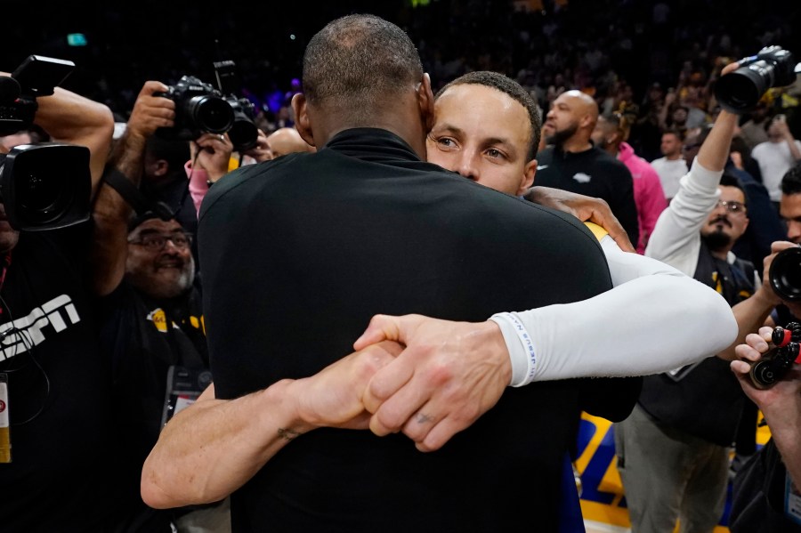 Los Angeles Lakers forward LeBron James, back to camera, hugs Golden State guard Stephen Curry after Game 6 of an NBA basketball Western Conference semifinal series Friday, May 12, 2023, in Los Angeles. Los Angeles won 122-101 to take the series and advance to the conference championship. (AP Photo/Ashley Landis)