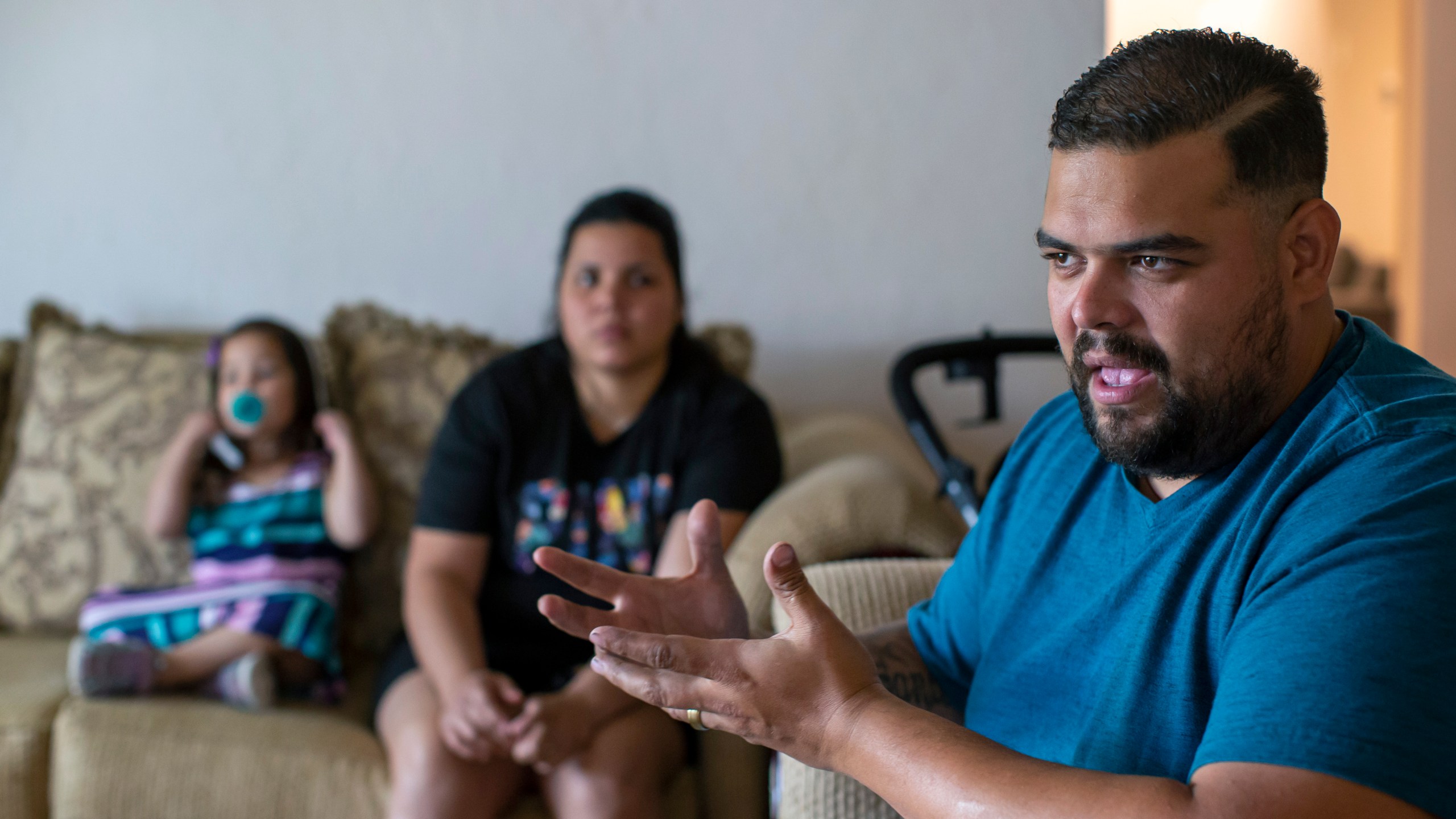 Venezuelan asylum-seeker Luis Lopez speaks with The Associated Press, as his wife, Oriana Marcano, and daughter Amaloha Lopez listen in El Paso, Texas, Friday, May 12, 2023. When Lopez was lost in Panama's Darien Gap last year with his pregnant wife, their two children and her grandmother, he often knelt in the mud to beg God not to abandon them. (AP Photo/Andres Leighton)