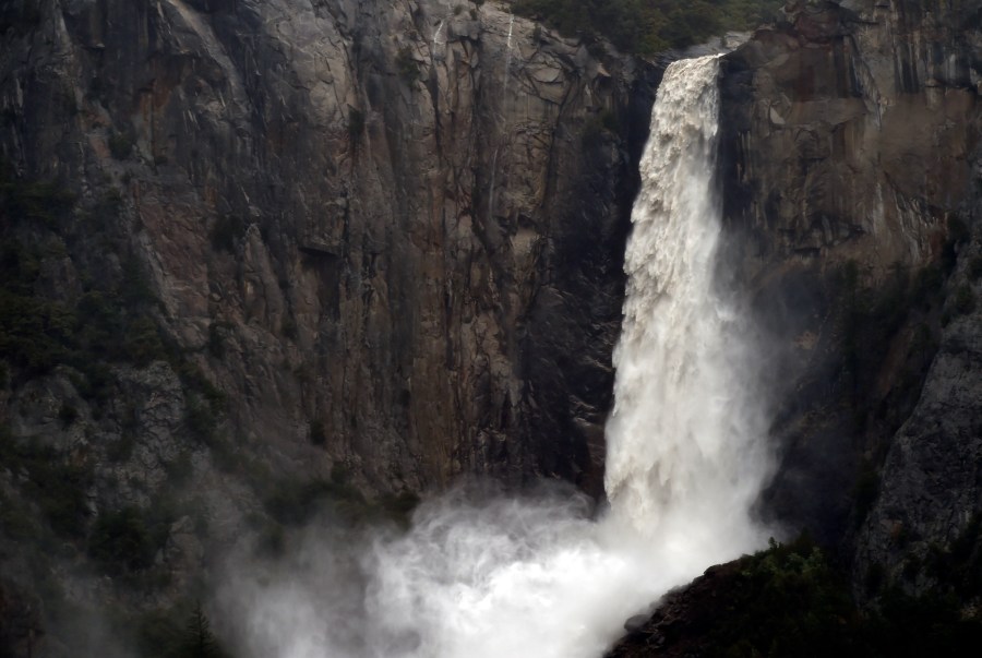 FILE - In this April 7, 2018, file photo, the raging Bridalveil Fall plummets into Yosemite Valley, while closed to the public due to a flooding Merced River, in Yosemite National Park, Calif. Three popular campgrounds at California's Yosemite National Park will be temporarily closed starting Monday, May 15, 2023, due to a forecast of flooding as warming temperatures melt the Sierra Nevada's massive snowpack. Park officials said Sunday that Lower and North Pines Campgrounds and Housekeeping Camp will be shut over fears that waterways could overspill their banks. (Eric Paul Zamora/The Fresno Bee via AP, File)