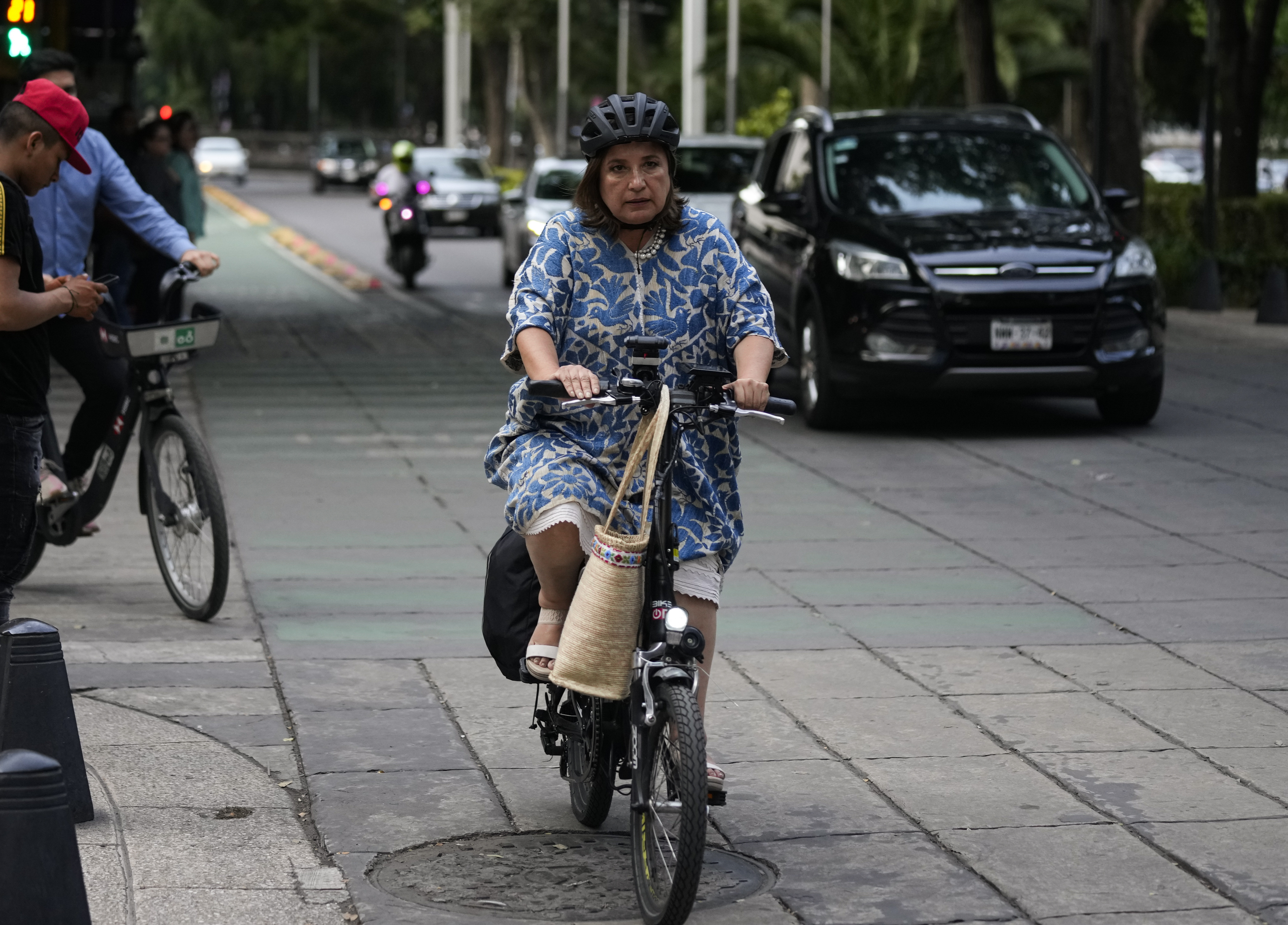 FILE - Senator Xochitl Galvez, an opposition presidential hopeful, rides a bike upon her arrival to a hotel for the announcement of the opposition presidential candidates in Mexico City, Wednesday, Aug. 9, 2023. The main opposition parties declared on Wednesday, August 30, 2023, Galvez as their virtual candidate for the upcoming presidential elections. (AP Photo/Fernando Llano, File)