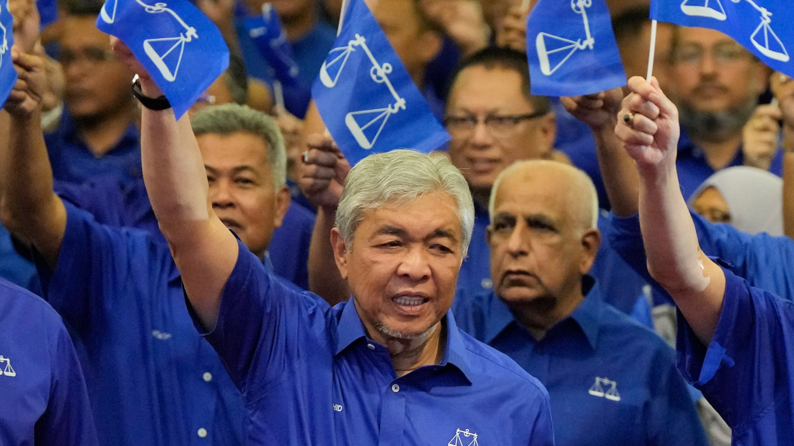 FILE - United Malays National Organization (UMNO) and Barisan National (National Front) coalition President Ahmad Zahid Hamidi, foreground, waves coalition flags during an event naming general election candidates at a hotel in Kuala Lumpur, Malaysia on Nov. 1, 2022. A Malaysian court on Monday, Sept. 4, 2023 dismissed 47 corruption charges against Deputy Prime Minister Ahmad Zahid Hamidi at an advanced stage of his trial. (AP Photo/Vincent Thian, File)