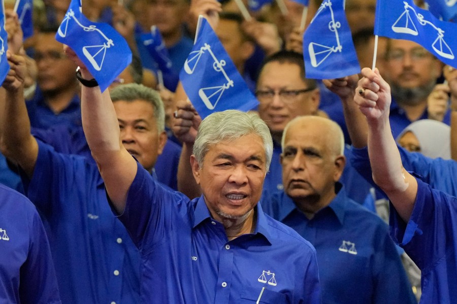 FILE - United Malays National Organization (UMNO) and Barisan National (National Front) coalition President Ahmad Zahid Hamidi, foreground, waves coalition flags during an event naming general election candidates at a hotel in Kuala Lumpur, Malaysia on Nov. 1, 2022. A Malaysian court on Monday, Sept. 4, 2023 dismissed 47 corruption charges against Deputy Prime Minister Ahmad Zahid Hamidi at an advanced stage of his trial. (AP Photo/Vincent Thian, File)