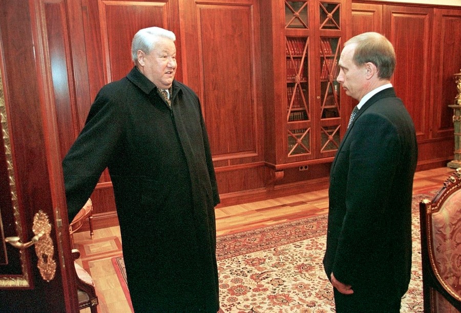 FILE - In this file photo taken on Friday, Dec. 31, 1999, former President Boris Yeltsin smiles as he holds a door before leaving his study as his successor, Vladimir Putin, listens in the Kremlin, in Moscow, Russia. (Sputnik, Kremlin Pool Photo via AP, File)