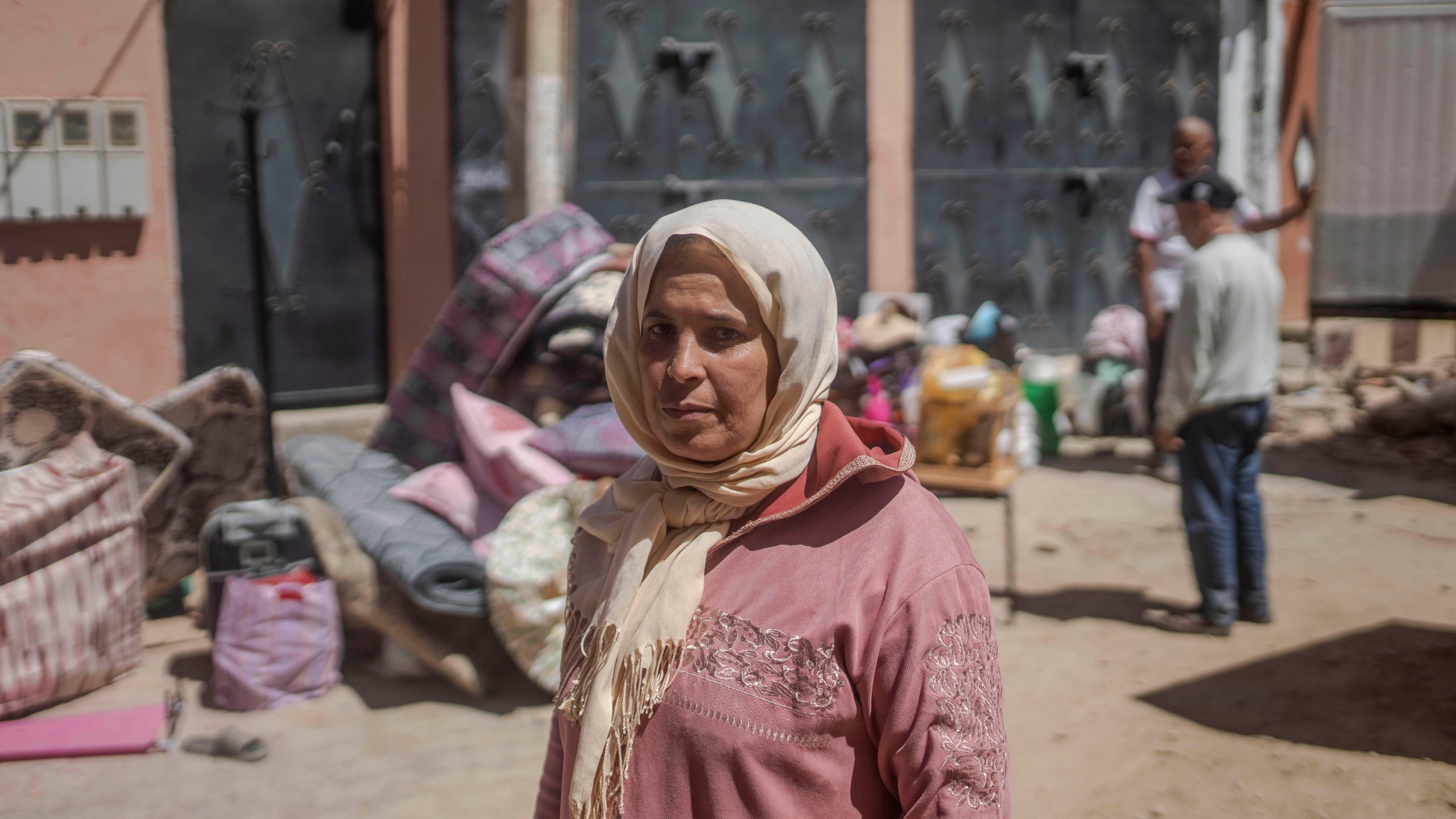 Hafida Fairouje looks on as residents gather their belongings after their houses were damaged by the earthquake in Amizmiz, Morocco on Sunday, Sept. 10, 2023. Towns and villages throughout Morocco's Atlas Mountains are mourning the dead and seeking aid after a record earthquake wreaked destruction throughout the region last week. (AP Photo/Mosa'ab Elshamy)