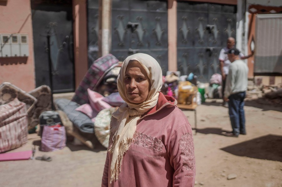 Hafida Fairouje looks on as residents gather their belongings after their houses were damaged by the earthquake in Amizmiz, Morocco on Sunday, Sept. 10, 2023. Towns and villages throughout Morocco's Atlas Mountains are mourning the dead and seeking aid after a record earthquake wreaked destruction throughout the region last week. (AP Photo/Mosa'ab Elshamy)