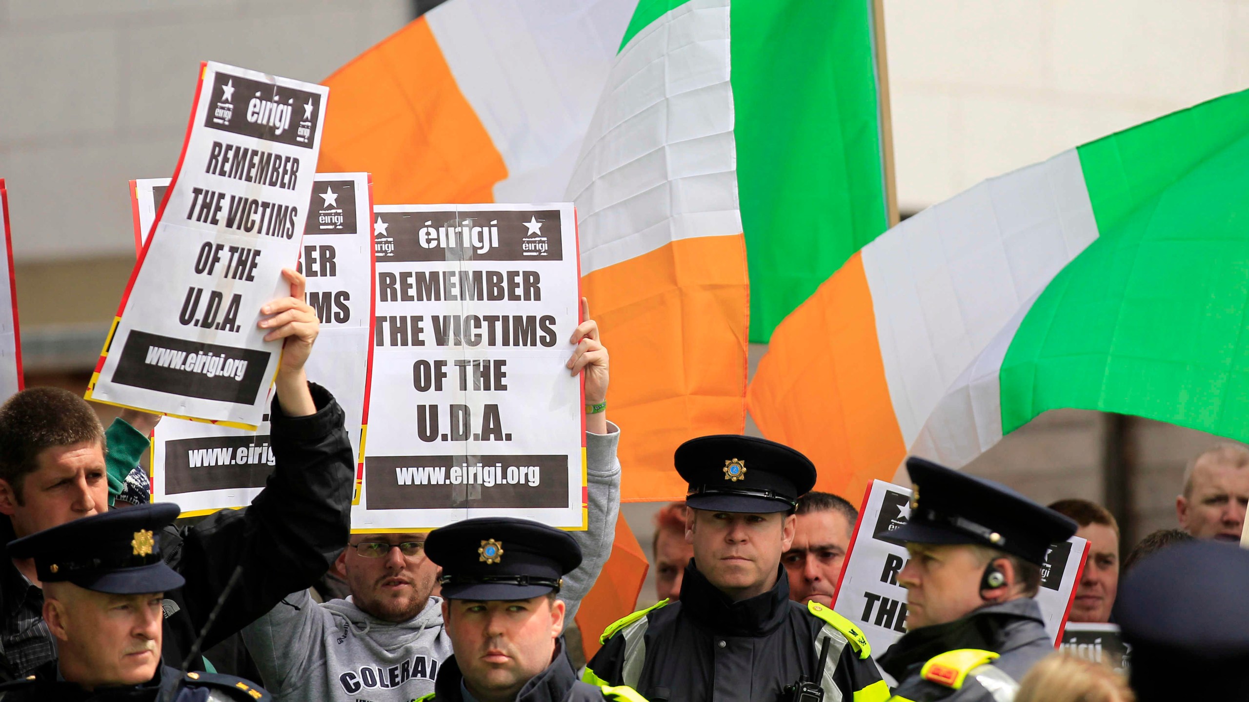 FILE - Irish police stand in front of supporters of the anti-British pressure group Eirigi as they take part in a protest against the state visit of Britain's Queen Elizabeth II to the Republic of Ireland in Dublin, May 18, 2011. Not a lot unites Northern Ireland’s fractious political and religious groups. The British government has managed it with a law that sets out to lay to rest the ghosts of decades of violence, but is opposed by all major political parties, Catholic and Protestant churches, human rights organizations and the United Nations. (AP Photo/Matt Dunham, File)