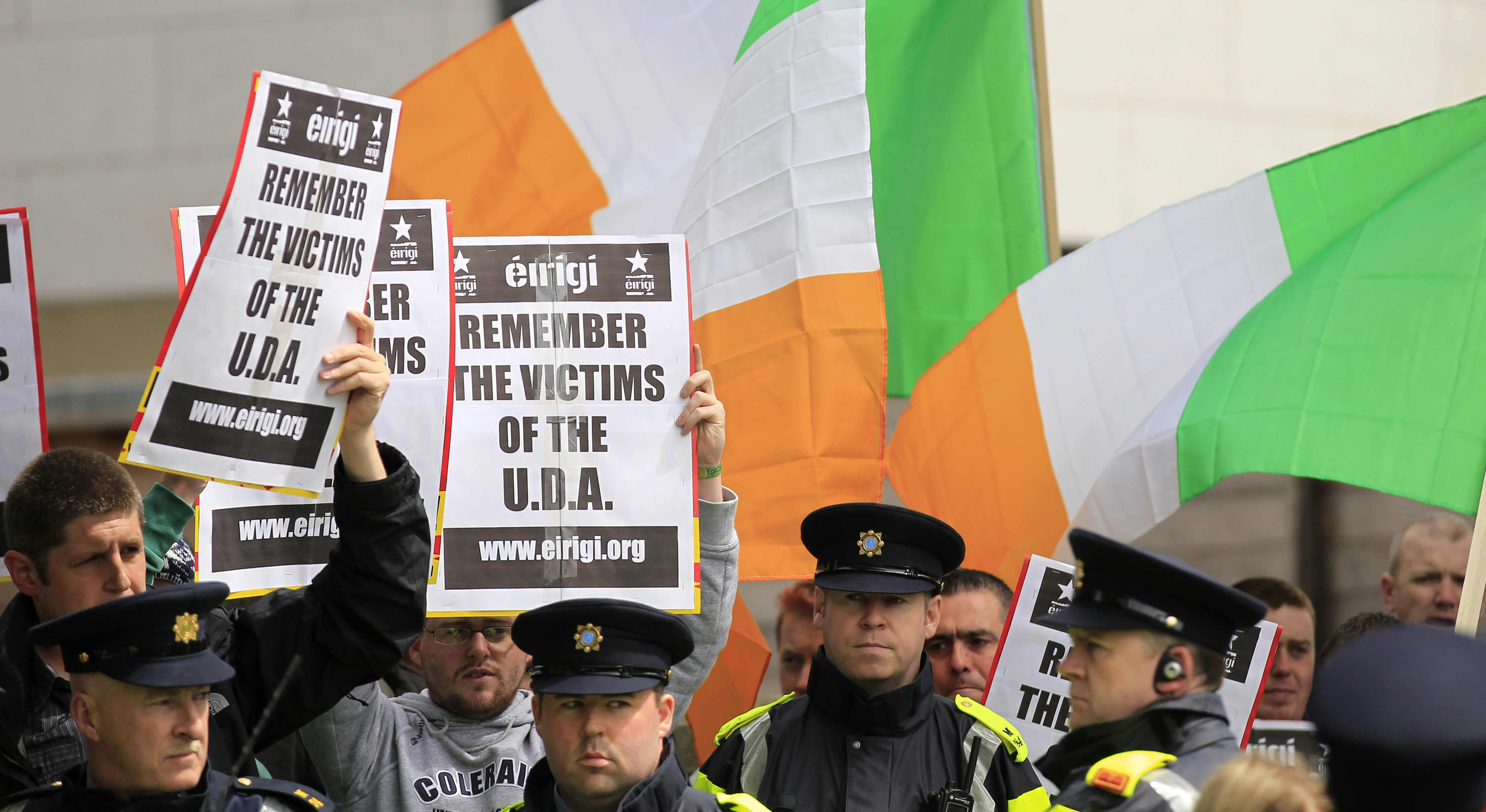 FILE - Irish police stand in front of supporters of the anti-British pressure group Eirigi as they take part in a protest against the state visit of Britain's Queen Elizabeth II to the Republic of Ireland in Dublin, May 18, 2011. Not a lot unites Northern Ireland’s fractious political and religious groups. The British government has managed it with a law that sets out to lay to rest the ghosts of decades of violence, but is opposed by all major political parties, Catholic and Protestant churches, human rights organizations and the United Nations. (AP Photo/Matt Dunham, File)