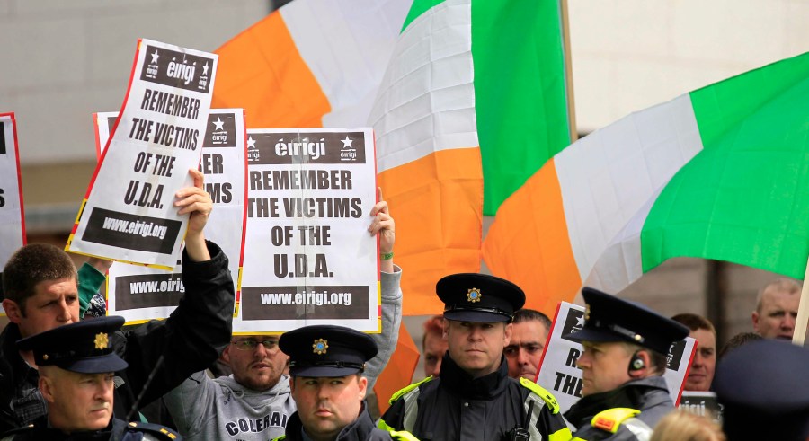 FILE - Irish police stand in front of supporters of the anti-British pressure group Eirigi as they take part in a protest against the state visit of Britain's Queen Elizabeth II to the Republic of Ireland in Dublin, May 18, 2011. Not a lot unites Northern Ireland’s fractious political and religious groups. The British government has managed it with a law that sets out to lay to rest the ghosts of decades of violence, but is opposed by all major political parties, Catholic and Protestant churches, human rights organizations and the United Nations. (AP Photo/Matt Dunham, File)