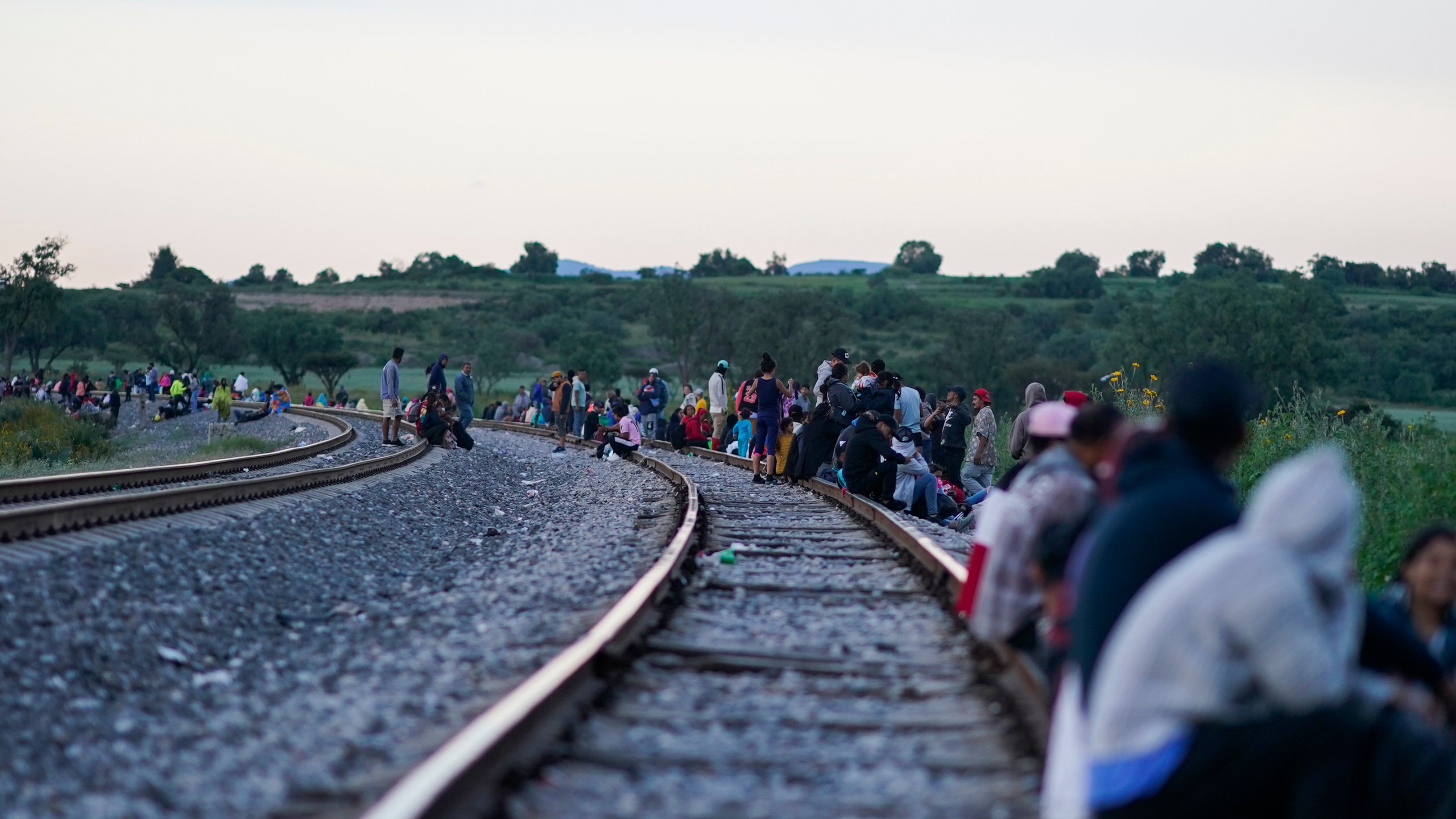 Migrants wait along rail lines hoping to board a freight train heading north, one that stops long enough so they can hop on, in Huehuetoca, Mexico, Sept. 19, 2023. Ferromex, Mexico's largest railroad company announced that it was suspending operations of its cargo trains due to the massive number of migrants that are illegally hitching a ride on its trains moving north towards the U.S. border. (AP Photo/Eduardo Verdugo)