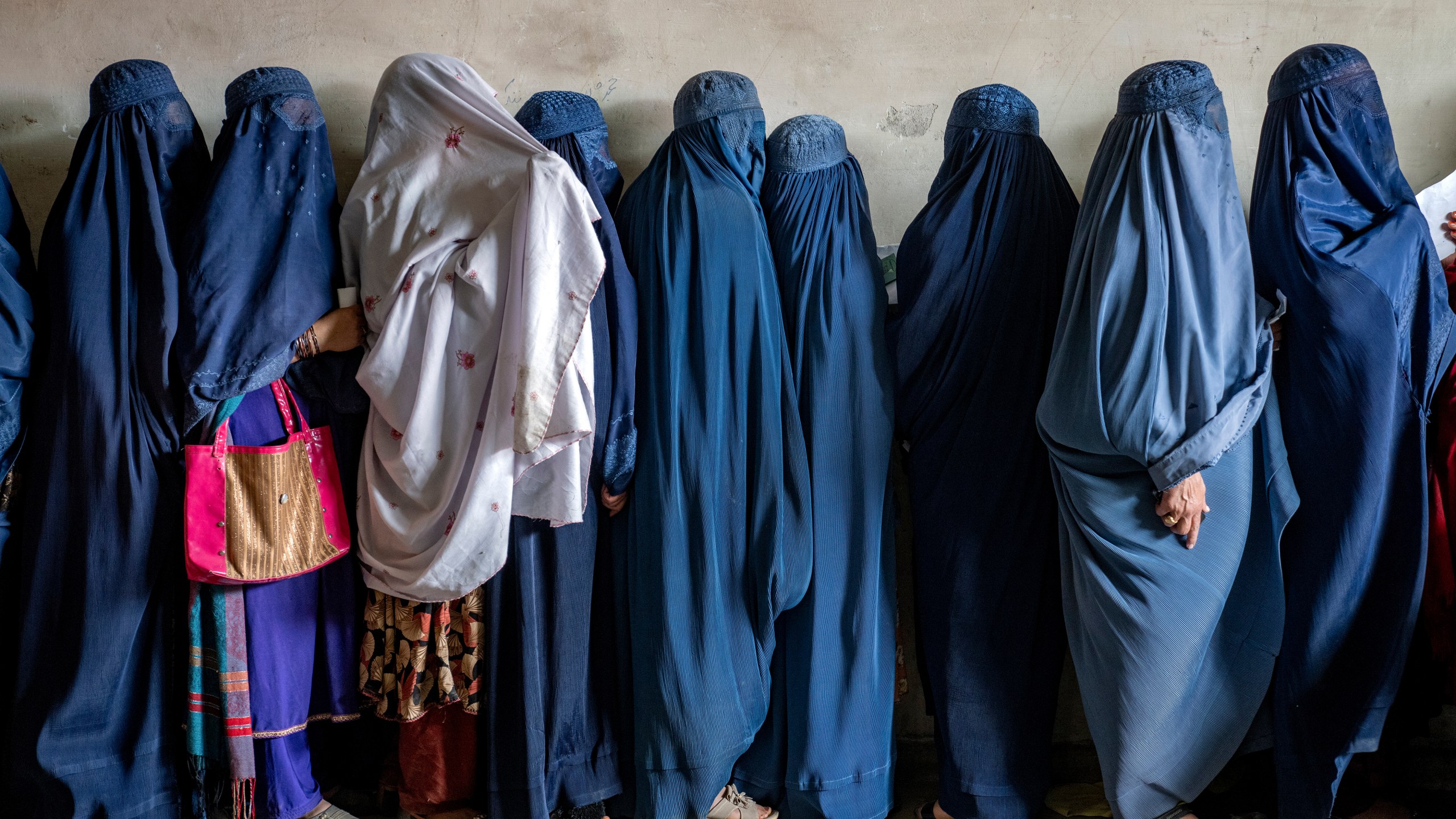 FILE - Afghan women wait to receive food rations distributed by a humanitarian aid group, in Kabul, Afghanistan, Tuesday, May 23, 2023. The mental health of Afghan women, who have suffered under harsh measures imposed by the Taliban since taking power two years ago, has deteriorated across the country, according to a joint report from three U.N. agencies released Tuesday, Sept. 19, 2023. (AP Photo/Ebrahim Noroozi, File)