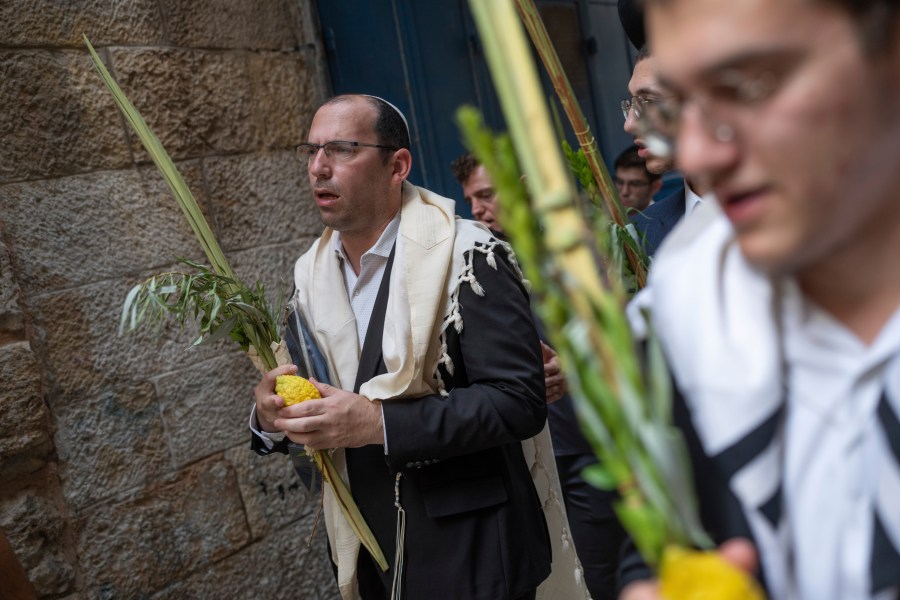 Israeli lawmaker Simcha Rothman takes part in a prayer during a weeklong Jewish holiday of Sukkot, next to one of the gates to the Temple Mount, known to Muslims as the Noble Sanctuary, or the Al-Aqsa Mosque compound, in the Old City of Jerusalem, Wednesday, Oct. 4, 2023. (AP Photo/Ohad Zwigenberg)