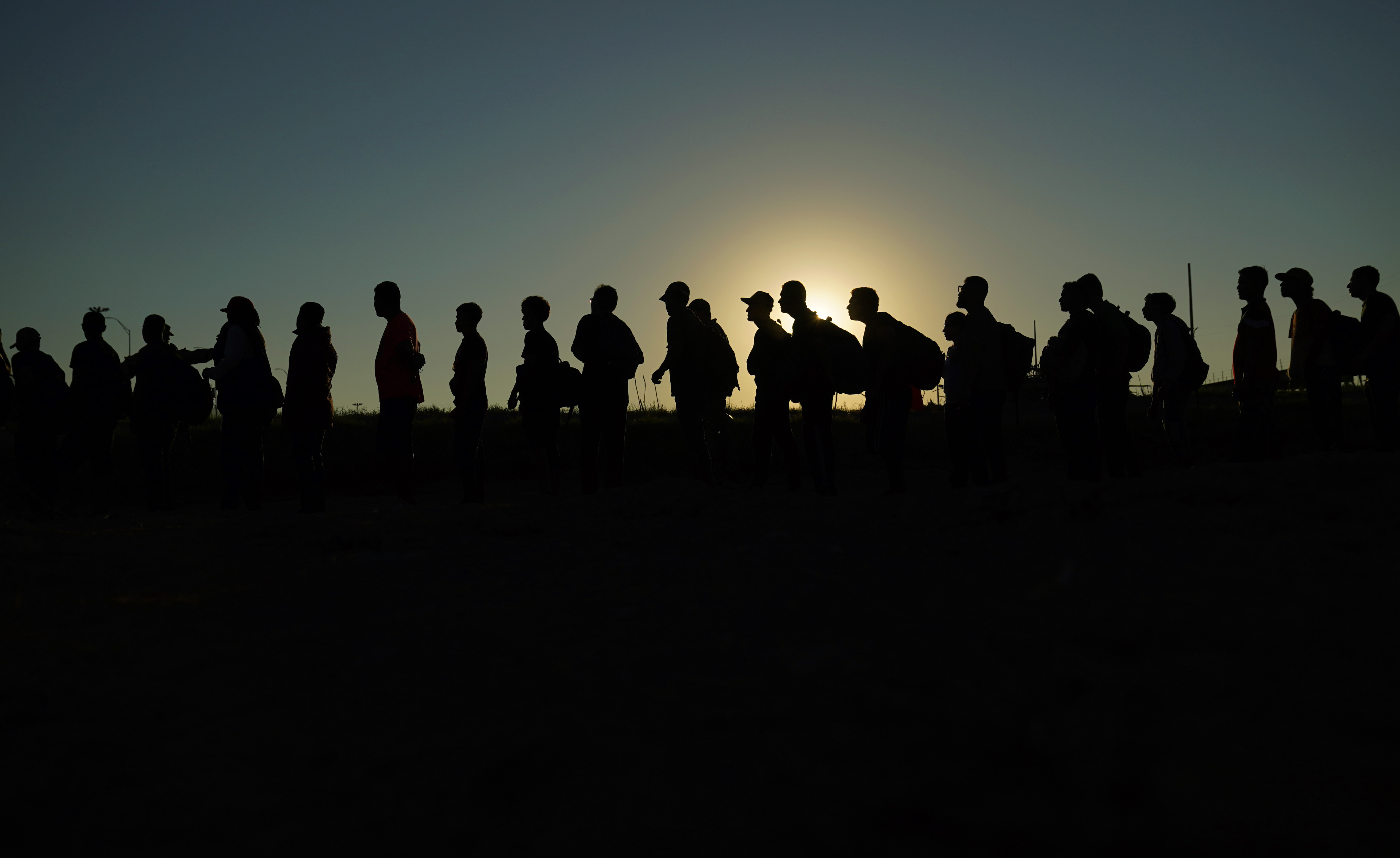 FILE - Migrants who crossed the Rio Grande and entered the U.S. from Mexico are lined up for processing by U.S. Customs and Border Protection, Sept. 23, 2023, in Eagle Pass, Texas. As the number of migrants coming to the U.S.'s southern border is climbing, the Biden administration aims to admit more refugees from Latin America and the Caribbean over the next year. The White House Friday, Sept. 29, released the targets for how many refugees it aims to admit over the next fiscal year starting October 1 and from what regions of the world. (AP Photo/Eric Gay, File)