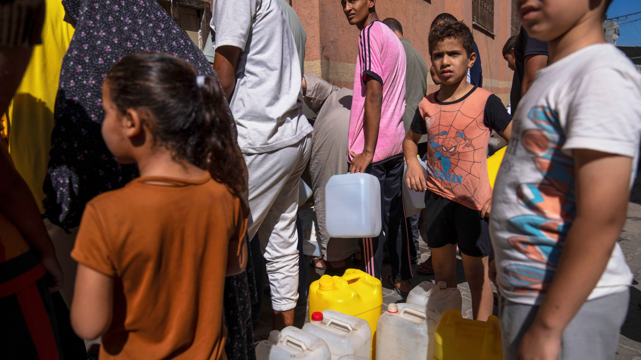 Palestinians collect water from a water tap, amid drinking water shortages, in Khan Younis, Gaza Strip, Sunday, Oct, 15, 2023. Israel cut off water to Gaza after a Hamas attack last week killed 1,300 people and Israel's retaliatory strikes killed more than 2,300 Palestinians. (AP Photo/Fatima Shbair)