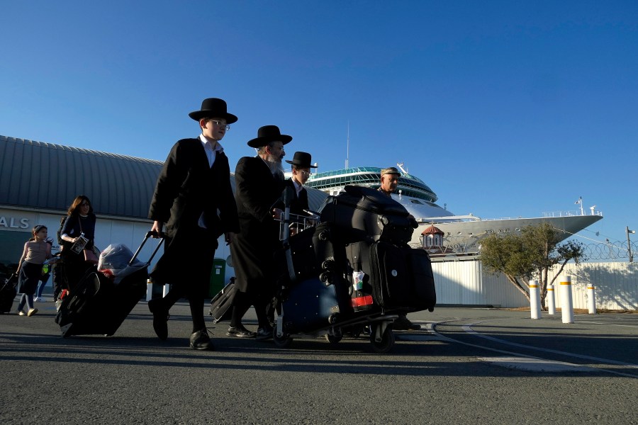 Ultra-Orthodox Jewish exit the arrivals lounge after disembarking from a cruise liner that brought them from Haifa, Israel, to the port in Limassol, Cyprus, on Tuesday, Oct. 17, 2023. U.S. government authorities arranged to ferry some 160 U.S. nationals and citizens of other countries aboard the cruise ship Rhapsody of the Seas, who opted to leave Israel ahead of an expected Israeli army assault on Hamas targets in the Gaza strip. (AP Photo/Petros Karadjias)