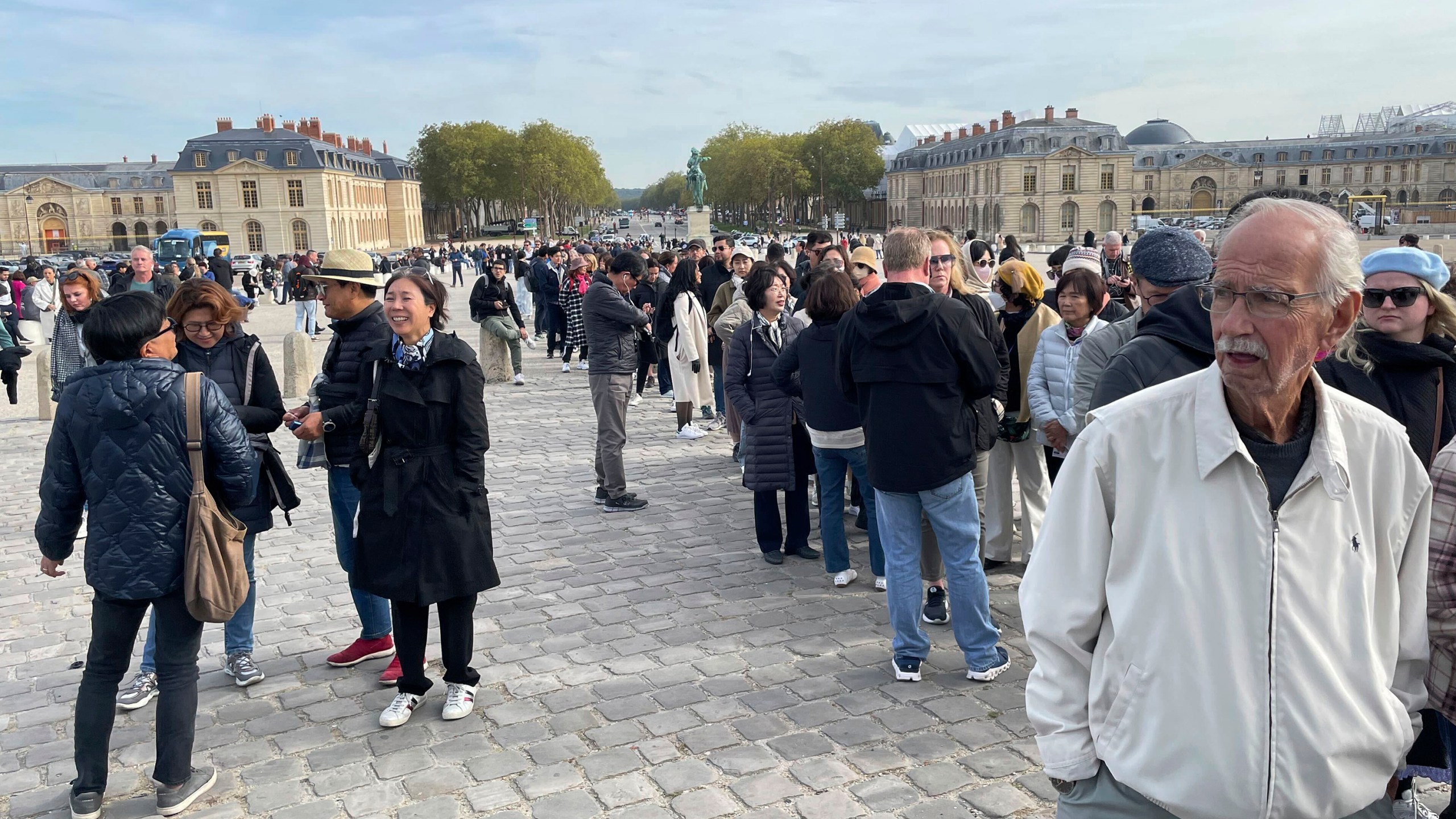 Tourist wait outside The Palace of Versailles on Tuesday, Oct. 17, 2023 in Versailles, France. One of France's most visited tourist attractions, was evacuated for a security scare, for the the second time in four days, with France on heightened alert against feared attacks after the fatal stabbing of a school teacher. (AP Photo/Pat Eaton-Robb)