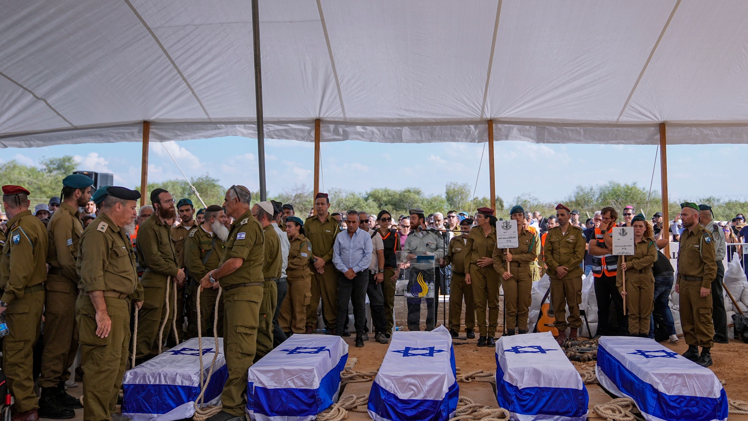 FILE - Mourners gather around the five coffins of the Kotz family during their funeral in Gan Yavne, Israel, Tuesday, Oct. 17, 2023. The family was killed by Hamas militants on Oct. 7, at their house in Kibbutz Kfar Azza near the border with the Gaza Strip. The war between Israel and Hamas has brought carefully calibrated condemnations and warnings to both sides by Russia. (AP Photo/Ohad Zwigenberg, File)