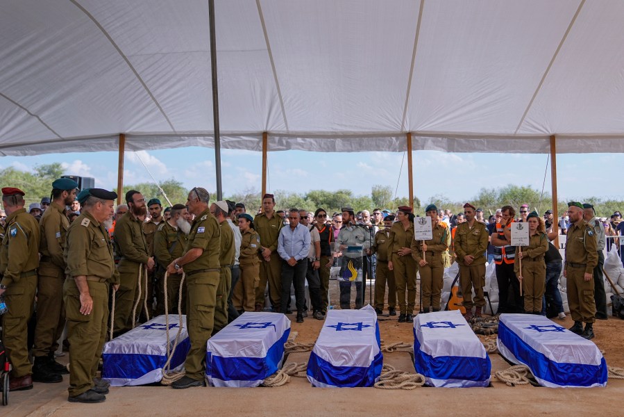 FILE - Mourners gather around the five coffins of the Kotz family during their funeral in Gan Yavne, Israel, Tuesday, Oct. 17, 2023. The family was killed by Hamas militants on Oct. 7, at their house in Kibbutz Kfar Azza near the border with the Gaza Strip. The war between Israel and Hamas has brought carefully calibrated condemnations and warnings to both sides by Russia. (AP Photo/Ohad Zwigenberg, File)