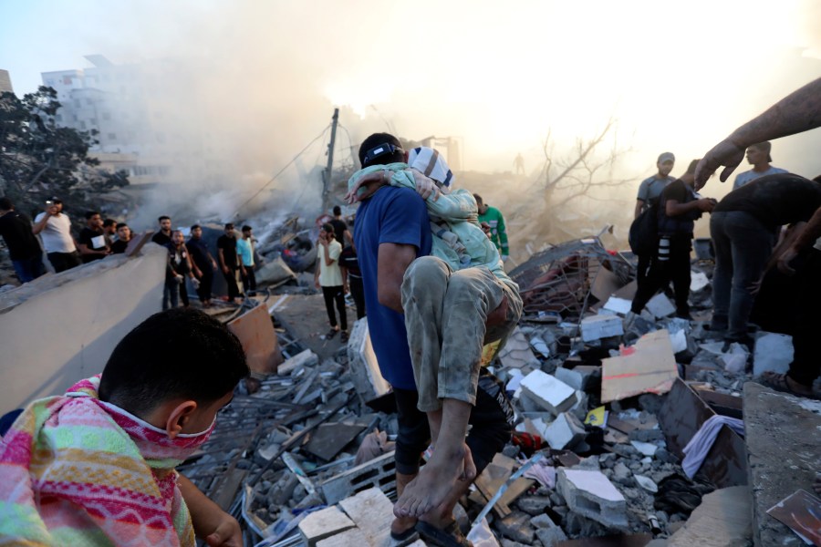 A Palestinian man evacuates a wounded girl out of the destruction following Israeli airstrikes on Gaza City, Wednesday, Oct. 25, 2023. The U.N. warned on Wednesday that it is on the verge of running out of fuel in the Gaza Strip, forcing it to sharply curtail relief efforts in the territory blockaded and devastated by Israeli airstrikes since Hamas militants launched an attack on Israel more than two weeks ago. (AP Photo/Abed Khaled)