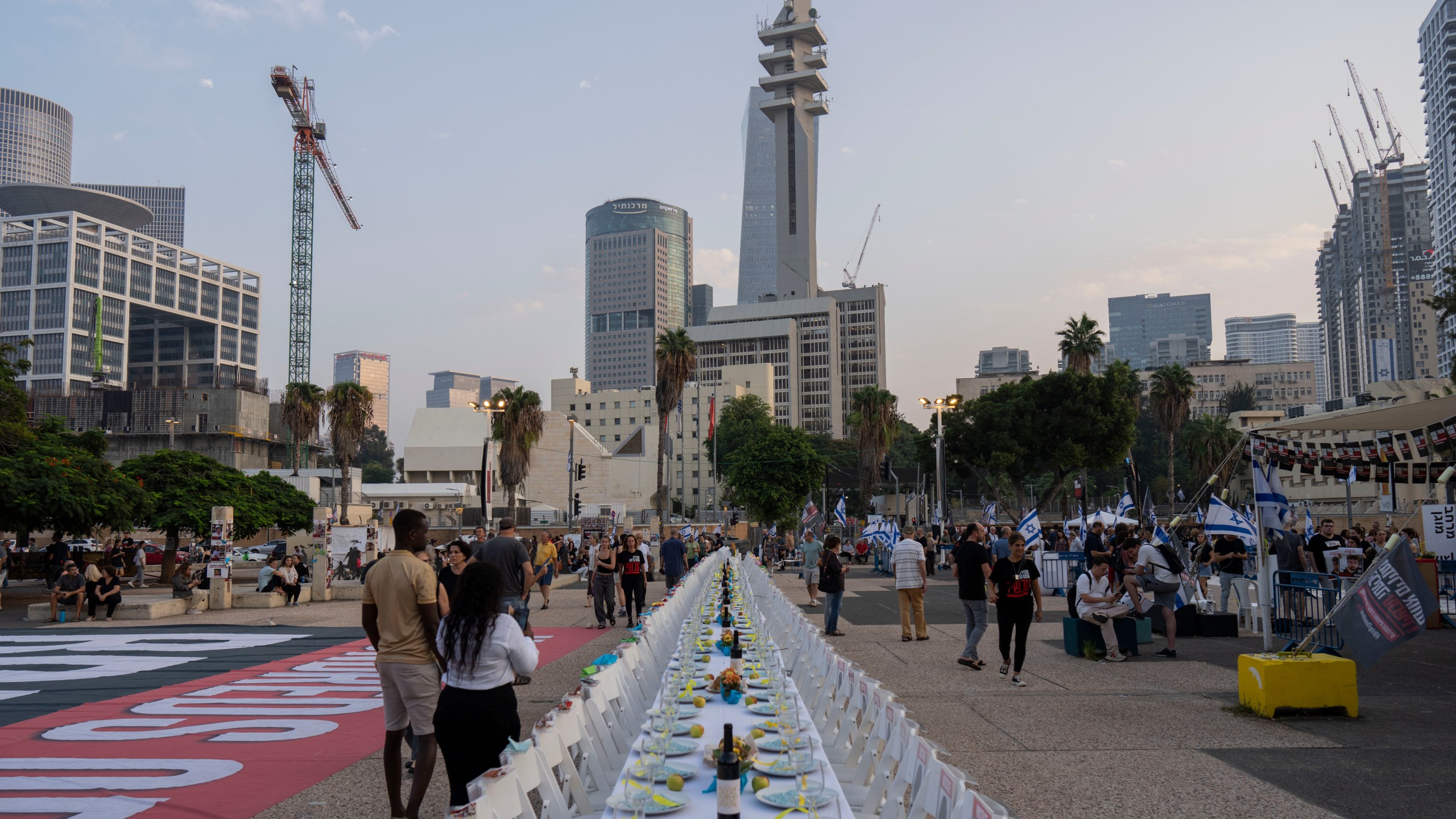 A sabbath table with empty chairs with pictures of the more than 220 people captured by Hamas militants is set in Tel Aviv, Israel, Saturday, Oct. 28, 2023. (AP Photo/Bernat Armangue)