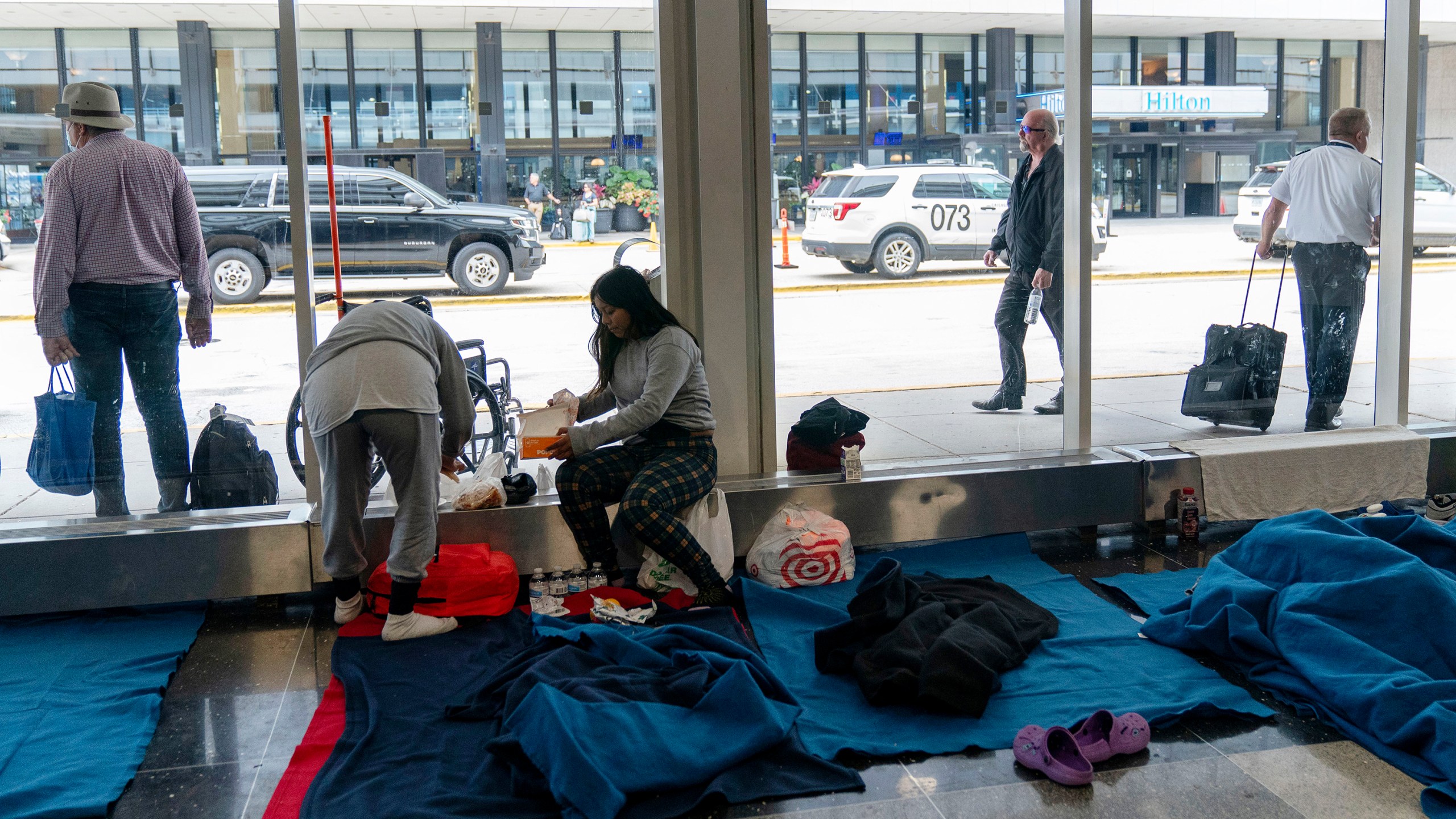 FILE - Run by a private firm hired by the city, migrants stay in a makeshift shelter at O'Hare International Airport, Sept. 20, 2023, in Chicago. Five mayors from around the U.S. want a meeting with President Joe Biden to ask for help controlling the continued arrival of large groups of migrants to their cities. The mayors of Denver, Chicago, Houston, New York and Los Angeles say in a letter to Biden that there has been little to no coordination, support or resources and that is leading to a crisis. (AP Photo/Erin Hooley, File Photo)