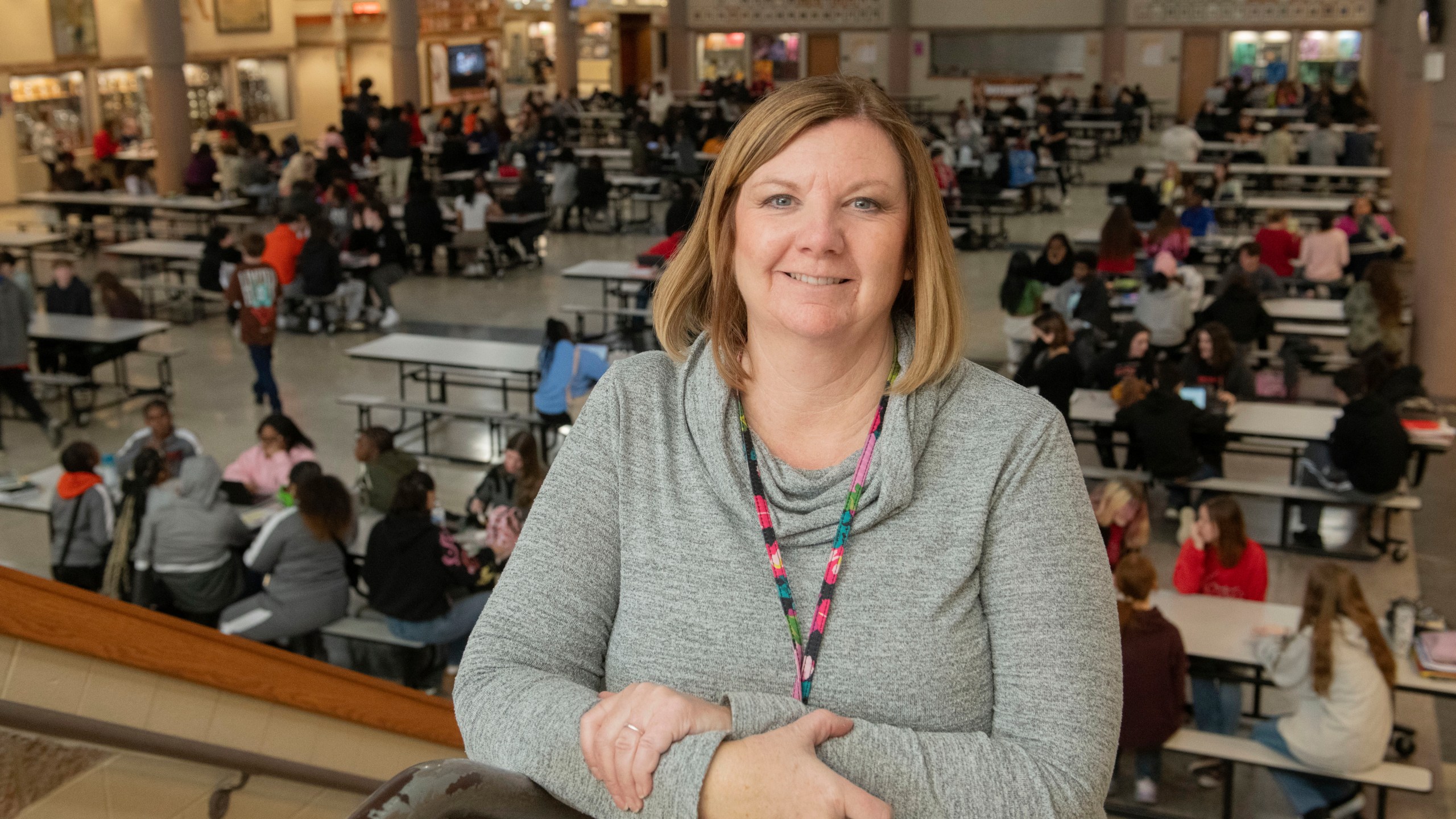 Mansfield Senior High School attendance coordinator Kari Cawrse stands with the school cafeteria in the background in Mansfield, Ohio, Friday, Dec. 6, 2024. (AP Photo/Phil Long)