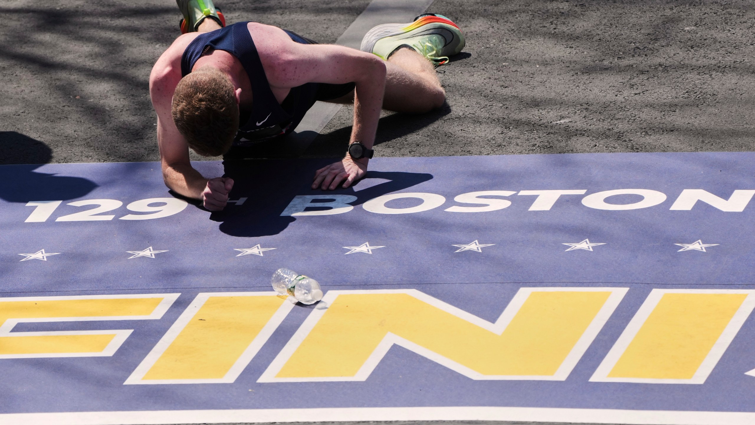 Runner Matthew Nawn crawls to cross the finish line during the Boston Marathon, Tuesday, April 22, 2025, in Boston. (AP Photo/Charles Krupa)
