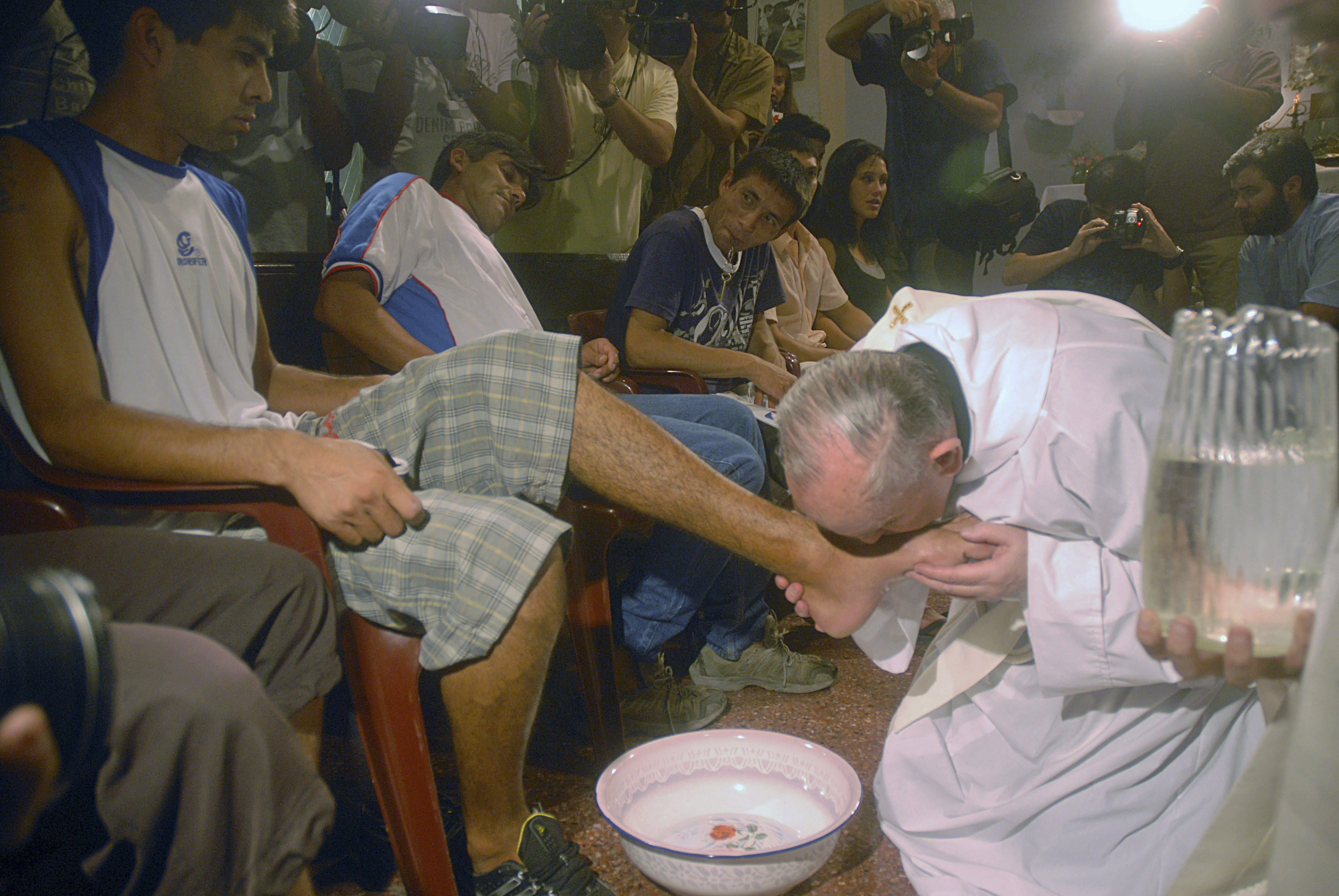 FILE - Argentina's cardinal Jorge Mario Bergoglio, right, kisses the foot of Cristian Marcelo Reynoso during a Mass with youth trying to overcome drug addictions in Buenos Aires, Argentina, Thursday, March 20, 2008. (AP Photo)